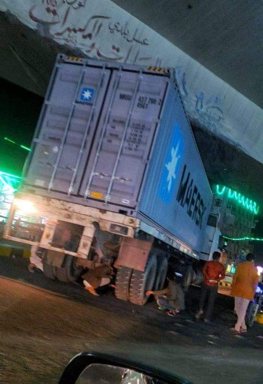 شاحنة كبيرة تعلق تحت جسر بيت بوس بالعاصمة صنعاء ومواطن يخرجها بحيلة ذكية ” صورة ” 